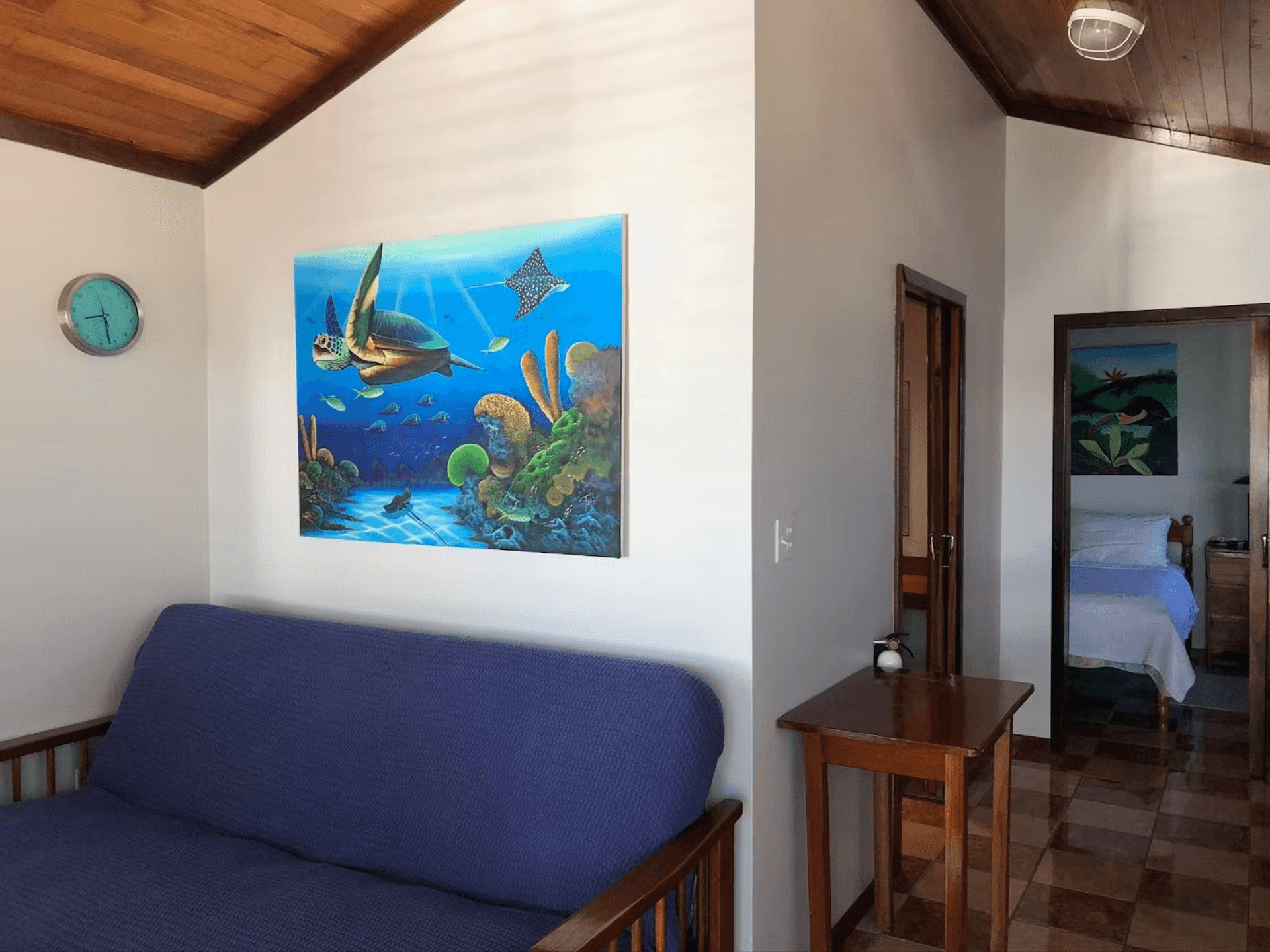 Sitting area with double futon, tropical sea artwork and vaulted hardwood ceilings