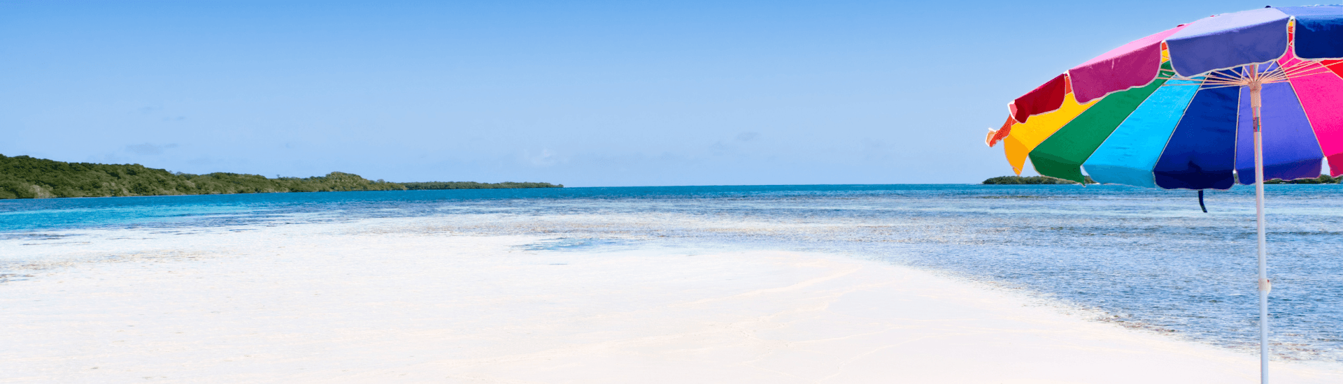 Multicolor umbrella on beach near the ocean